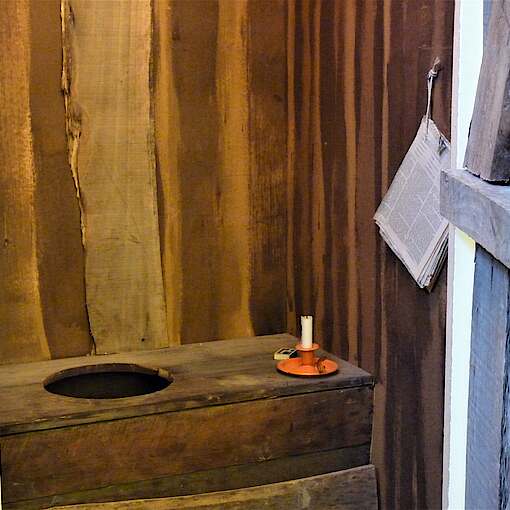 Bild Latrine / Plumsklo aus Holz in einer kleinen Zelle aus Holz